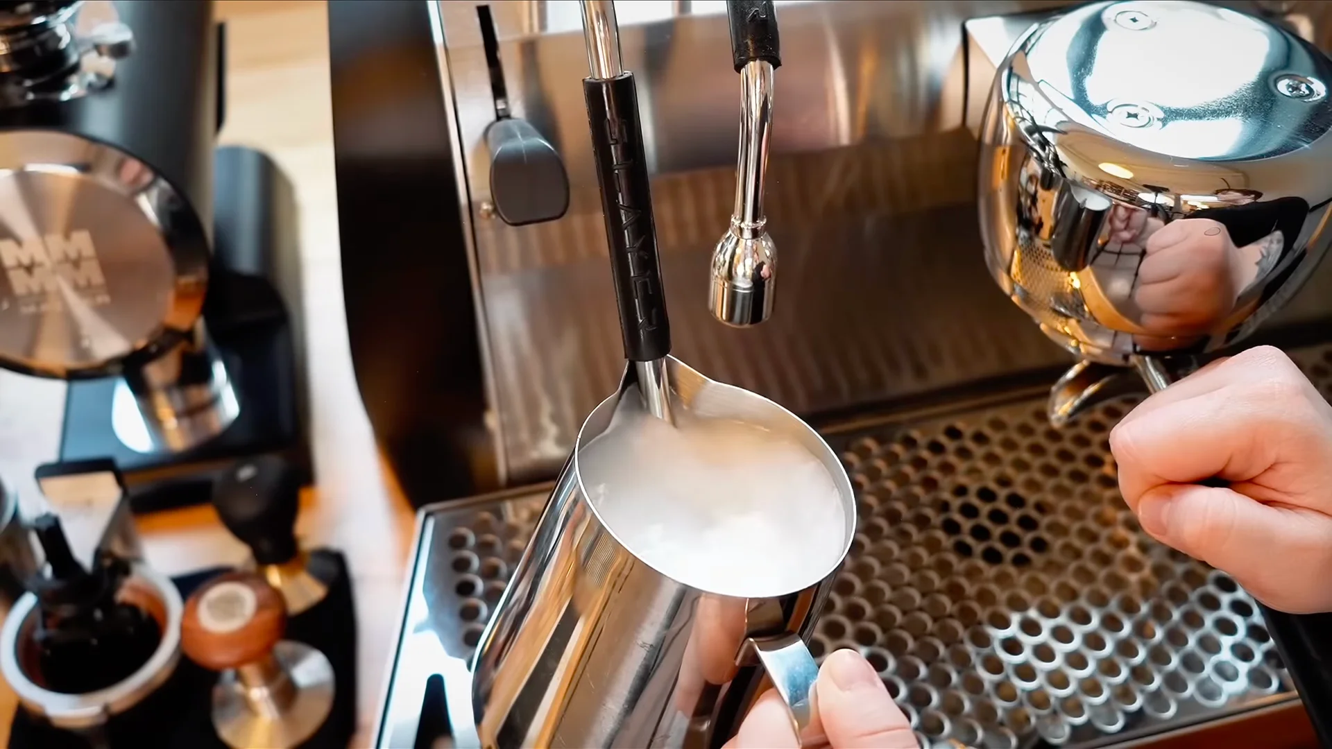 Prikaz iz blizine mlaznice za paru na aparatu za espreso sa ostacima suvog mleka, koji pokazuje potrebu za čišćenjem tokom održavanja kafe-opreme